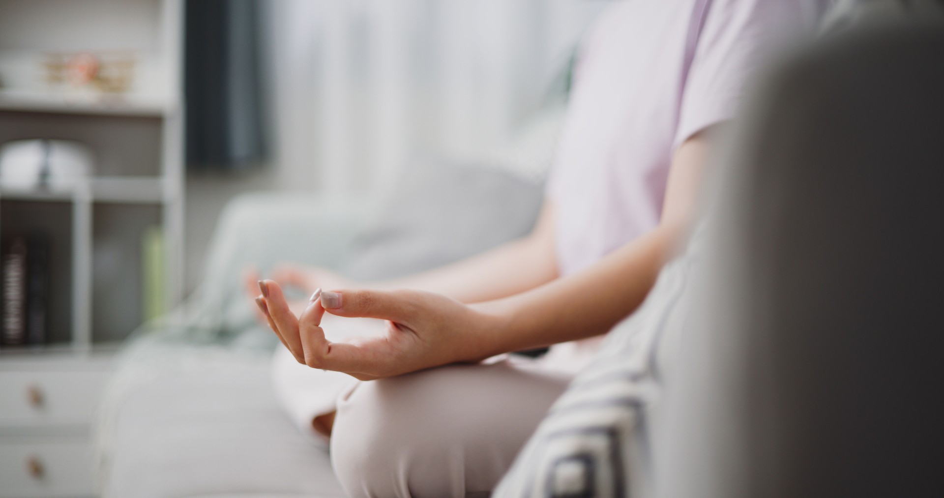 Beautiful Asian woman meditating in a peaceful atmosphere at home.